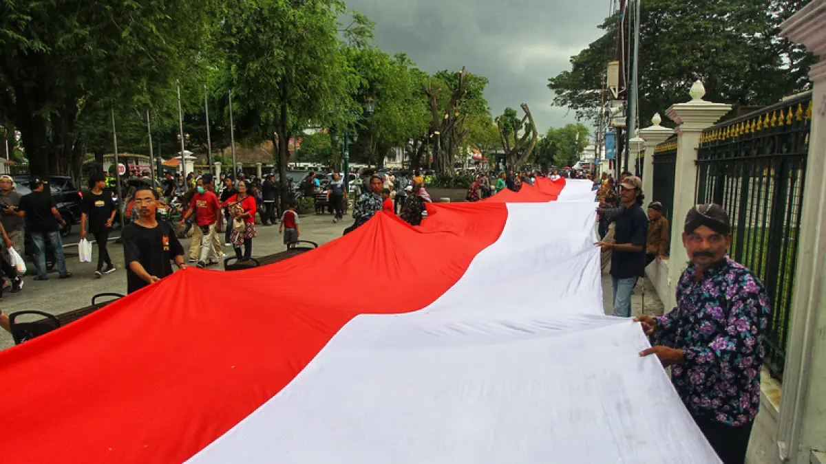 Sejumlah elemen masyarakat mengarak bendera Merah Putih sepanjang 100 meter saat aksi damai bertajuk "Jaga Jogja dengan Cinta", di kawasan Titik Nol Kilometer Kota Jogja, Rabu (29/4/2026). Guntur Aga Tirtana/Radar Jogja