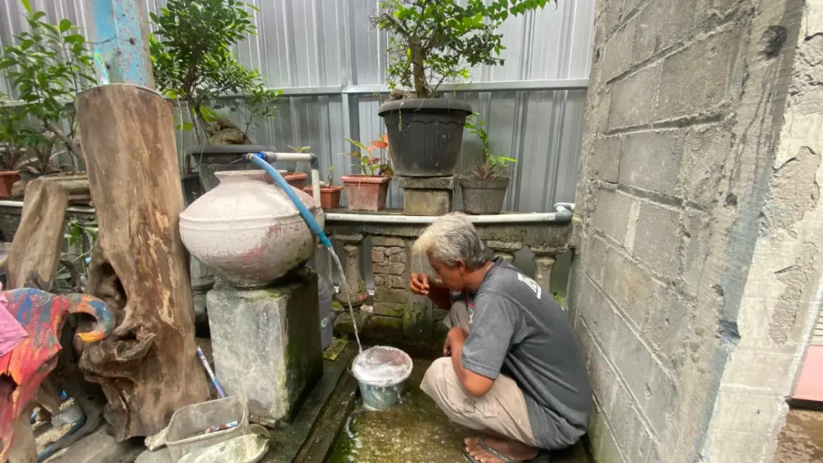 PENCEMARAN LIMBAH: Salah satu sumur warga yang terdampak Agus Indriyanto sedang mengecek air yang tercemar limbah dari SPPG Trimurti, Srandakan - Cintia Yuliani/Radar Jogja
