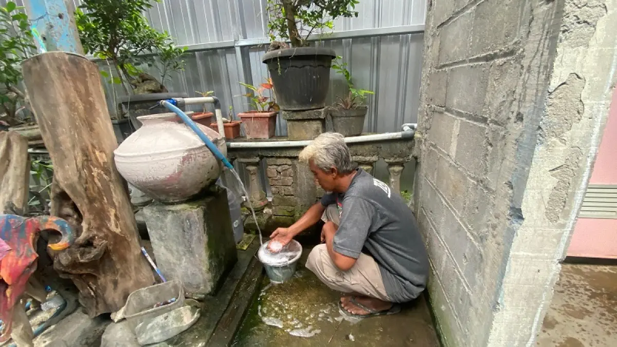 PENCEMARAN LIMBAH: Agus Indriyanto sedang mengecek air yang tercemar limbah dari SPPG Trimurti, Srandakan #004 Kamis (30/4/2026). Cintia&nbsp;Yuliani/Radar Jogja