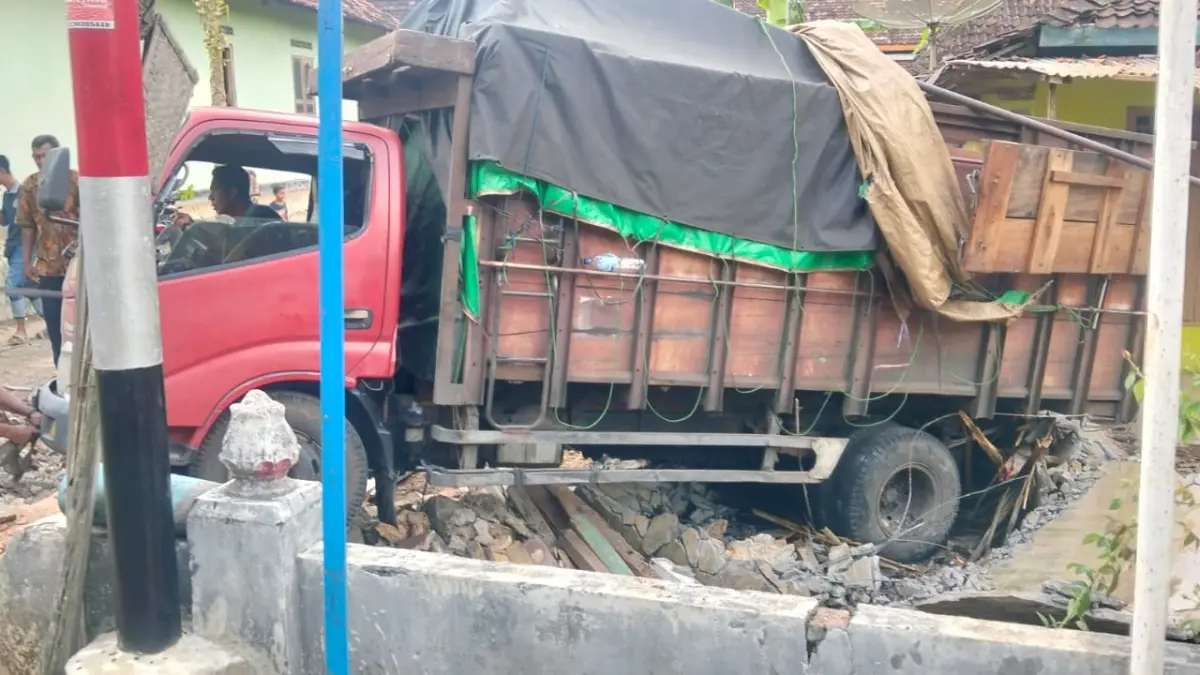 Truk pengangkut pakan ayam gagal nanjak hingga menghantam rumah warga.