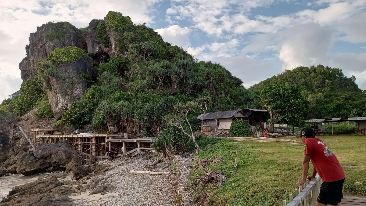 Warga Kapanewon Tanjungsari sedang memandangi pembangunan di area perbukitan karst Pantai Watu Bolong.