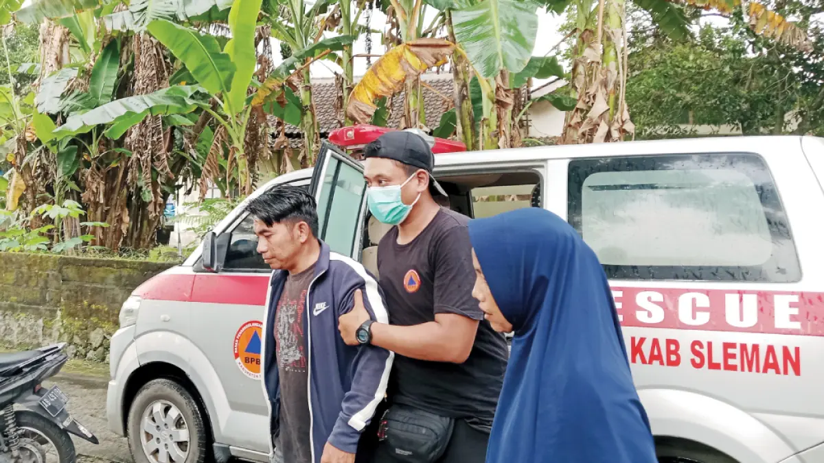 GEJALA SERUPA: Sebagian korban keracunan usai mengonsumsi nasi boks dari acara pengajian pamitan haji warga Getas Toragan, Tlogoadi, dipapah dari ambulans oleh petugas BPBD Sleman, kemarin (4/5). (Delima Purnamasari/Radar Jogja)