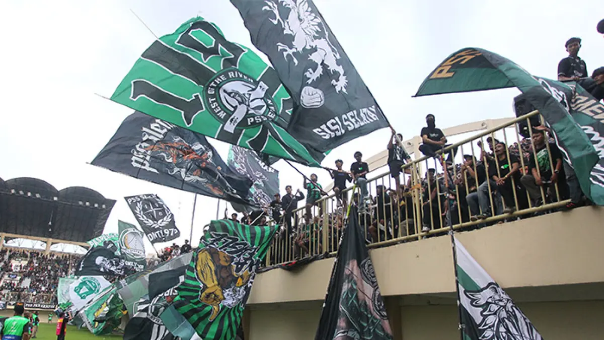 KIBARKAN GIANT FLAG: Suporter PSS Sleman saat mendukung tim kesayangannya saat menghadapi PSIS Semarang, Minggu (3/5). Dalam laga itu PSS Sleman menang dengan skor 3-0 dan otomatis lolos liga 1 musim depan.