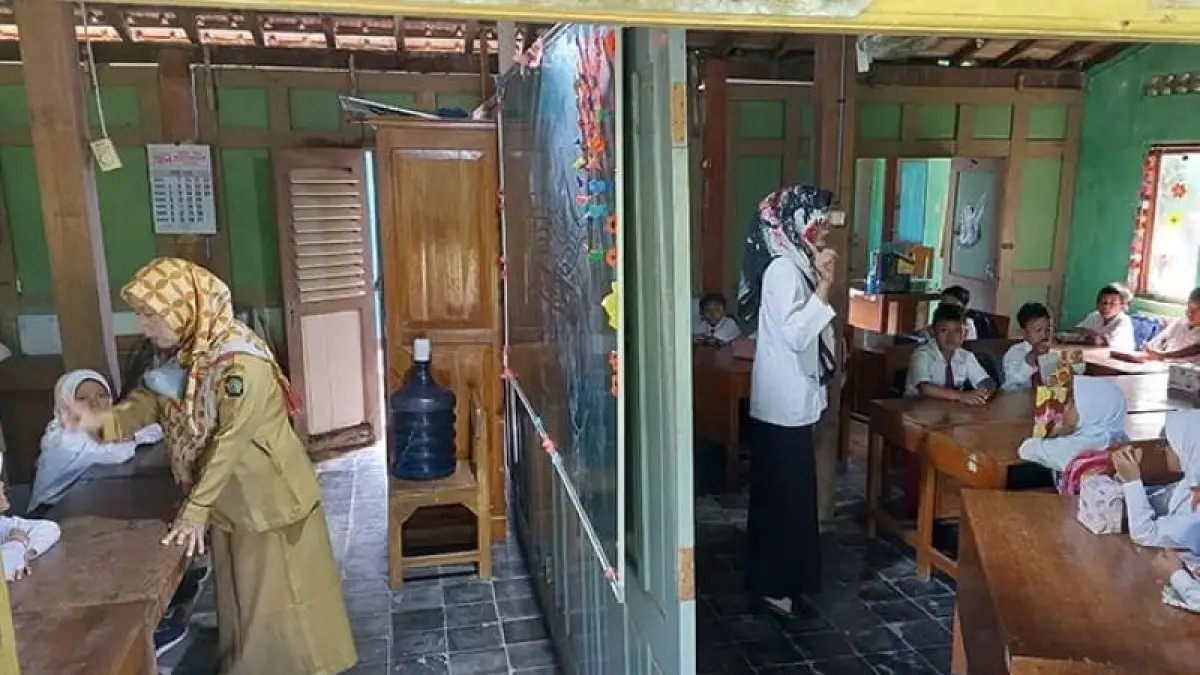 BERSEKAT: Guru SDN Bugel mengajar hanya berbatas sekat kayu saat bangunan sekolah sedang direhab, 2 April 2024. (ANOM BAGASKORO/RADAR JOGJA)
