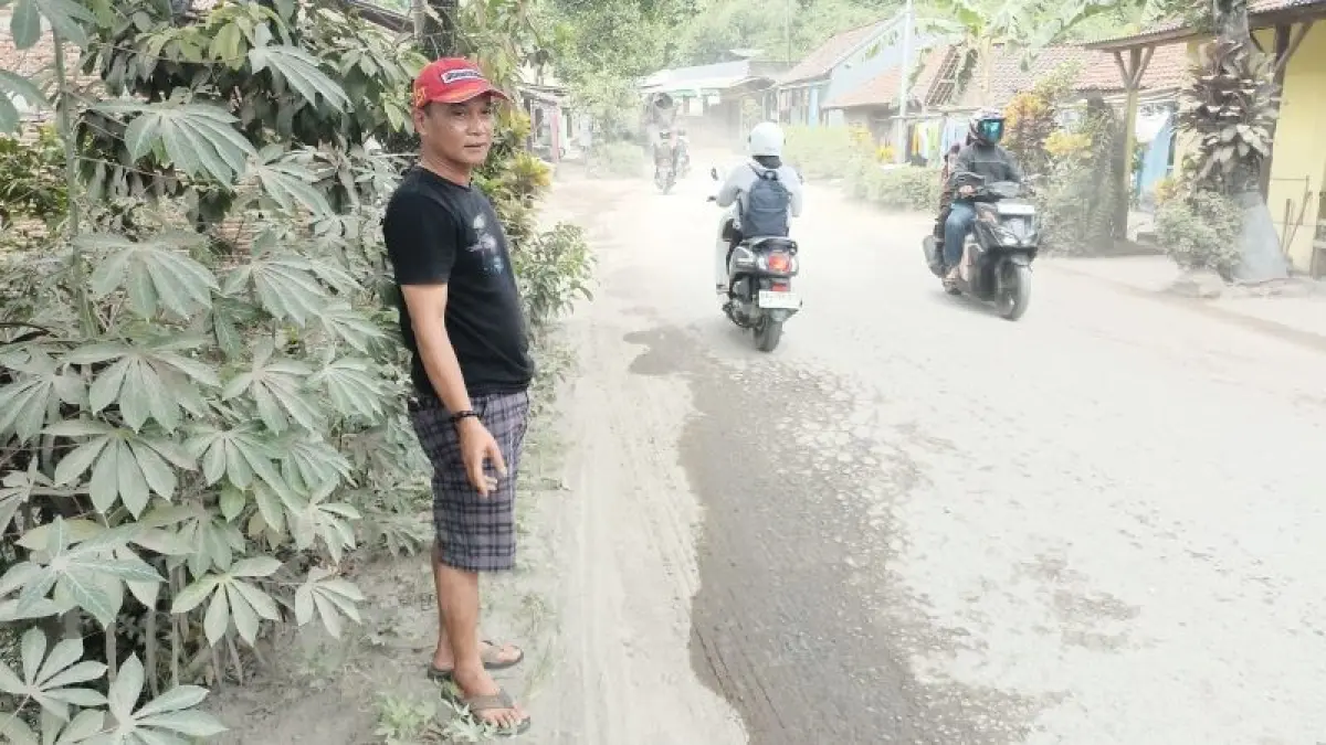 POLUSI: Kepala Desa Karangpoh, Kecamatan Pejagoan Dwi Ari Sunarko menunjukkan ketebalan debu akibat kondisi jalan rusak yang telah lama dikeluhkan warga. (M Hafied/Radar Jogja)