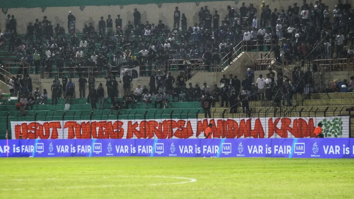 Spanduk sindiran bertuliskan "Usut Tuntas Korupsi Mandala Krida" yang dibentangkan suporter PSIM Jogja di sisi timur Stadion Sultan Agung, saat laga melawan Malut United, Minggu (10/5/2026). (GUNTUR AGA/RADAR JOGJA)