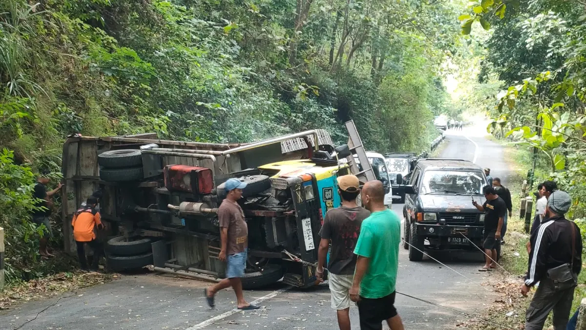Warga dan aparat setempat mencoba membalikkan kendaraan truk dan ekskavator.