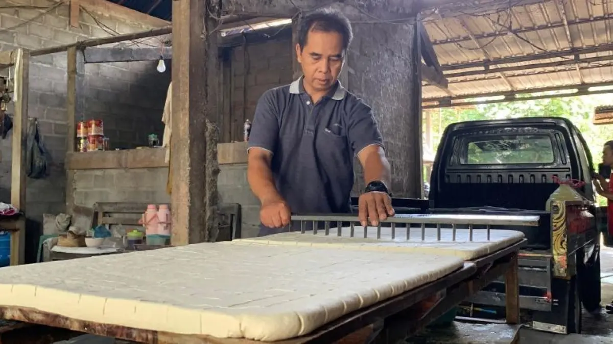 PRODUKSI: Pengrajin tahu di Kalurahan Tuksono mencetak tahu dengan alat pres lalu dipotong menjadi beberapa bagian. (ANOM BAGASKORO/RADAR JOGJA)