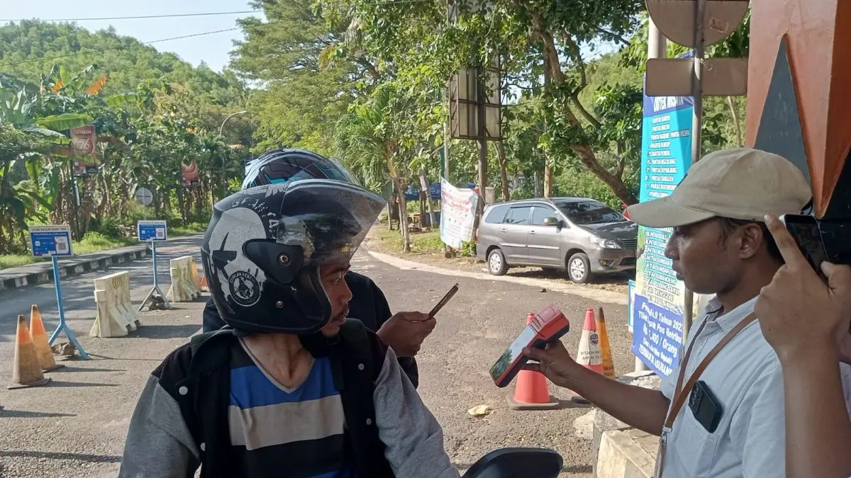 Wisatawan sedang memotret kode transaksi tiket retribusi di mesin Empos Pos TPR Baron - Yusuf Bastiar/Radar Jogja
