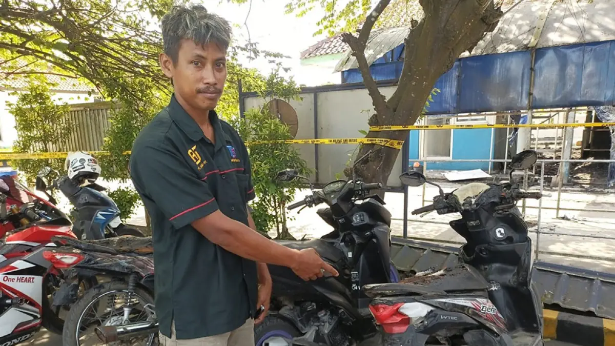 KENDARAAN TERDAMPAK: Seorang karyawan PT Arami Jaya menunjukkan kondisi motornya yang sempat ikut terbakar pada Kamis (14/5).&nbsp; M. Hafied/Radar Jogja
