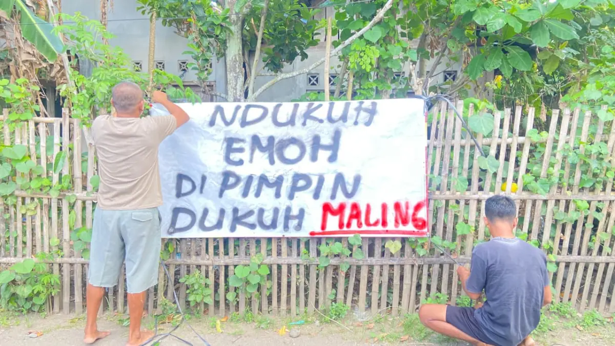 PENOLAKAN: Beberapa warga sedang bergotong royong memasang banner yang bertuliskan penolakan terhadap Dukuh Padukuhan Dukuh jika menjabat kembali Minggu (17/5) - Cintia Yuliani/Radar Jogja
