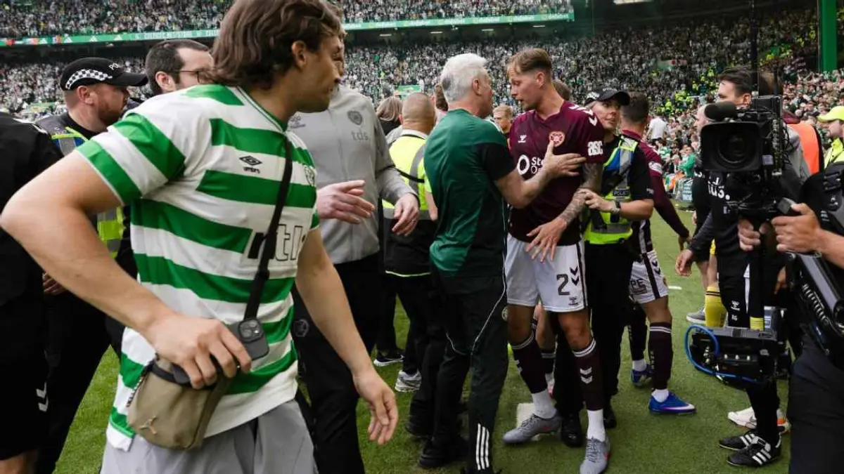 Suporter Celtic turun ke lapangan setelah Callum Osmand mencetak gol di masa injury time. (getty images)