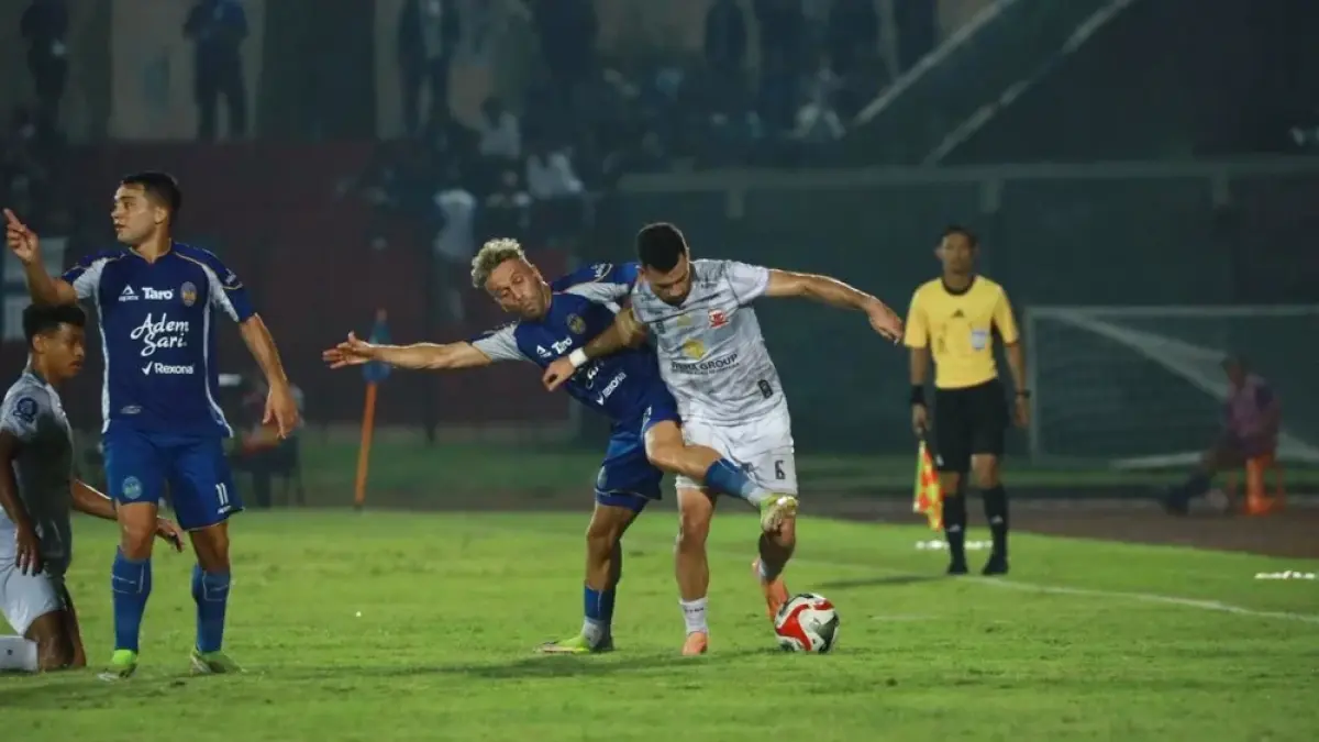 Penampilan pemain Madura United, Junior Brandao (putih) saat menguasai bola dari rebutan pemain PSIM Jogja, Ze Valente (biru).