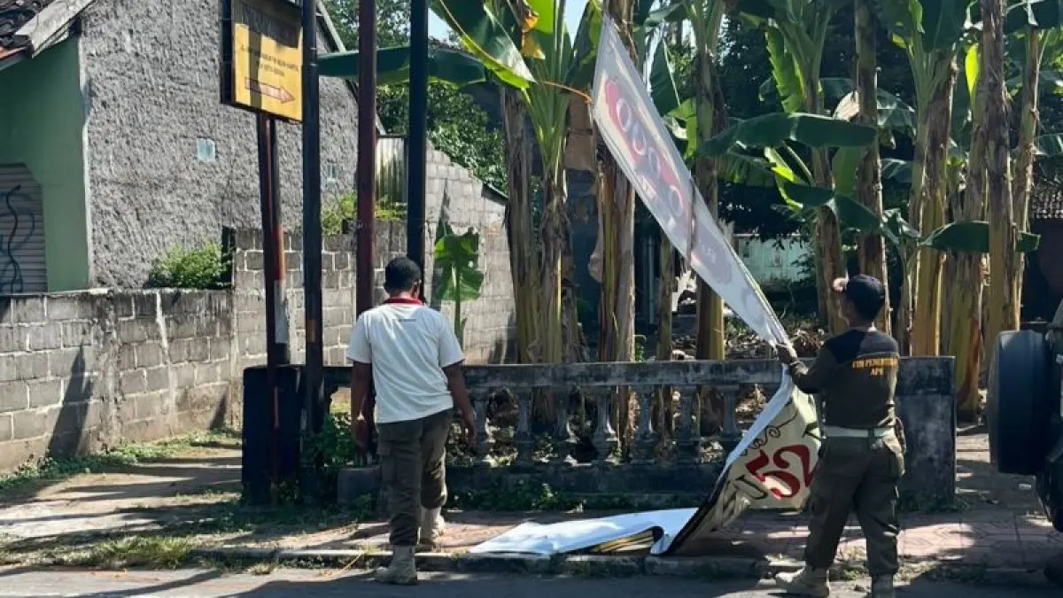 DITINDAK: Petugas Satpol PP Bantul sedang melepas spanduk yang melanggar aturan Rabu (13/5). (Dokumentasi Satpol PP Bantul)