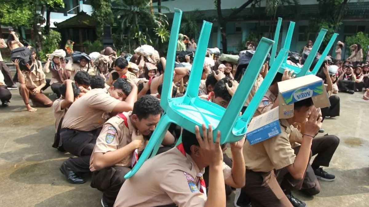 SIMULASI: Siswa SMA Negeri 1 Kalasan melindungi kepala mereka saat mengikuti simulasi penanganan bencana gempa bumi di sekolah mereka, Sleman Jumat (22/5).&nbsp;(Guntur Aga Tirtana/Radar Jogja)