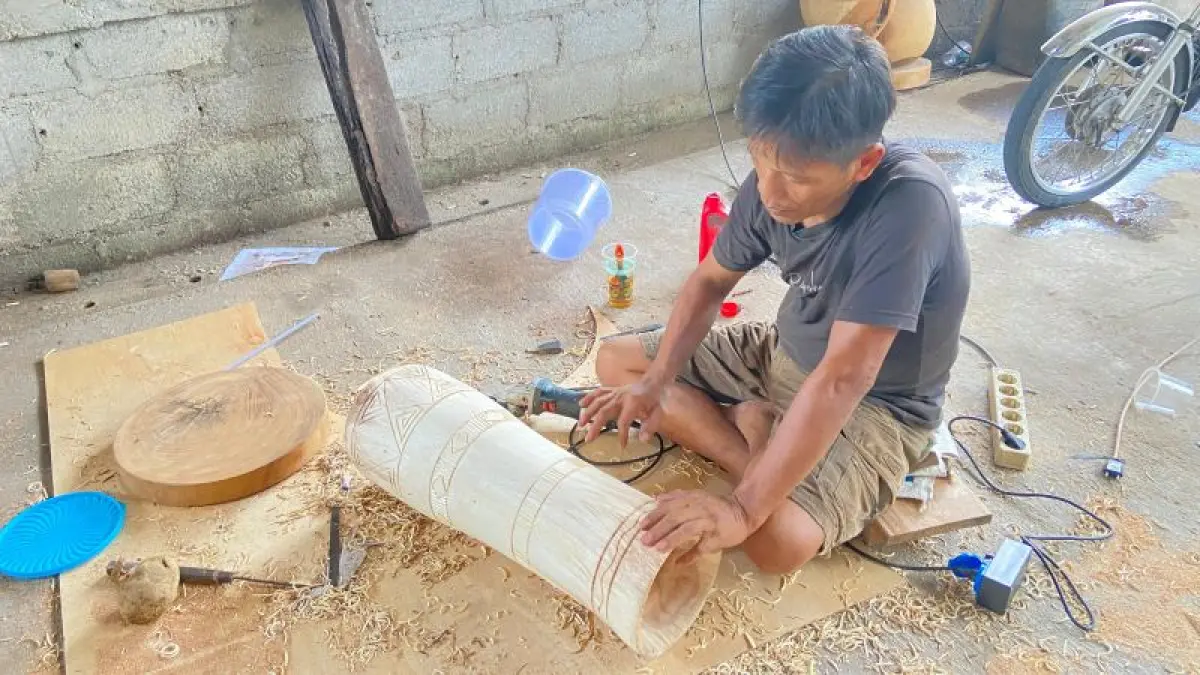 KREATIF: Perajin batik kayu Slamet Munggur sedang membuat vas bunga dari kayu. (Cintia Yuliani/Radar Jogja)