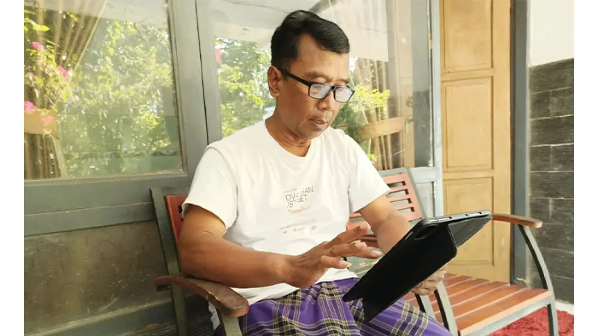 KREATIF: Mantan Camat Ayah, Arif Rahmadi sedang asyik memproduksi konten dengan tablet pintar miliknya. (M. Hafied/Radar Jogja)