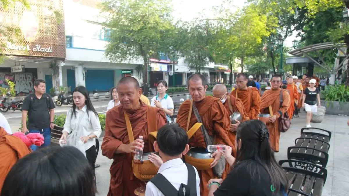ANTUSIAS: Warga memberikan derma kepada 57 Bhikkhu Thudong saat tradisi Pindapata di kawasan Malioboro, Kota Jogja Selasa (26/5).&nbsp;(Guntur Aga Tirtana/Radar Jogja)