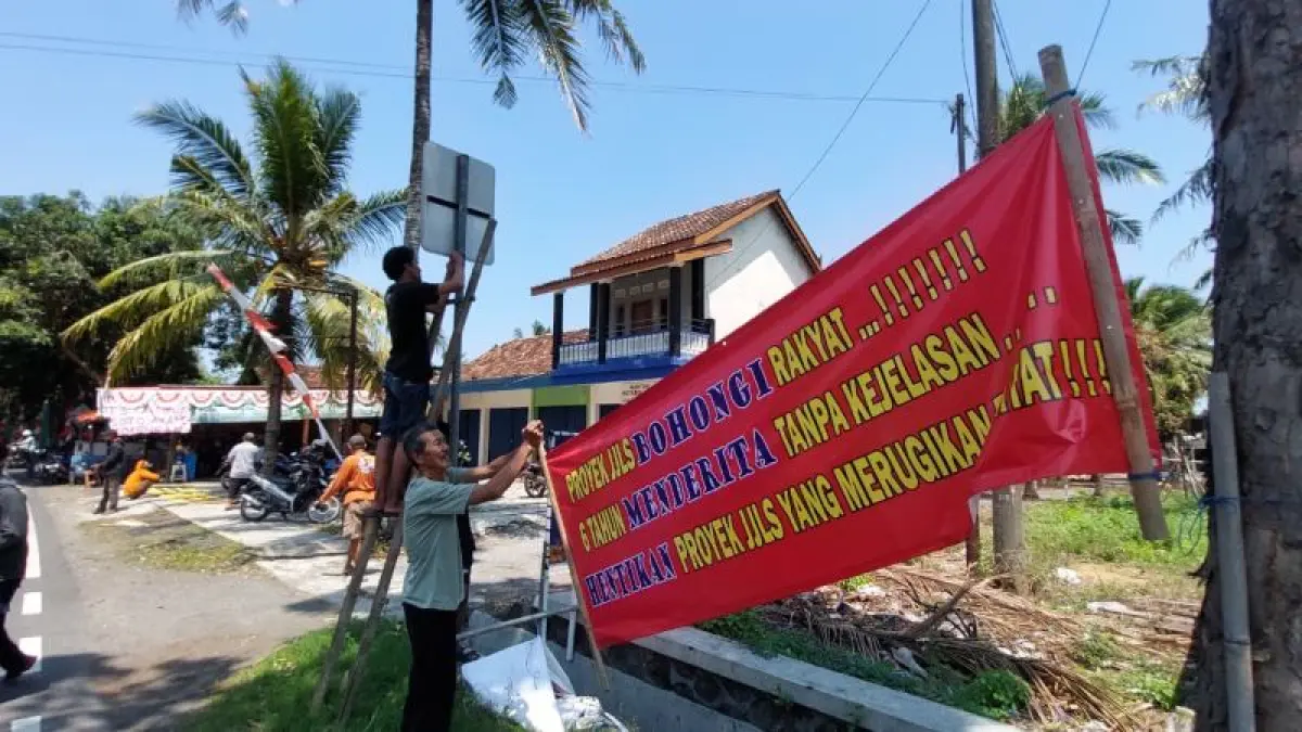PROTES: Warga Kalurahan Karangwuni memasang banner berisikan protes pertanyakan kelanjutan pengadaan tanah JJLS. (ANOM BAGASKORO/RADAR JOGJA)