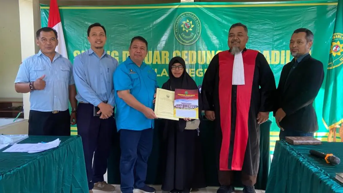 LEBIH DEKAT DENGAN PEMOHON: Kepala Disdukcapil Kabupaten Bantul Kwintarto Heru Prabowo (tiga dari kiri) menyerahkan berkas penerbitan akta kematian kepada pemohon di kantor Kalurahan Gilangharjo, Selasa (26/5). (Cintia Yuliani/Radar Jogja)