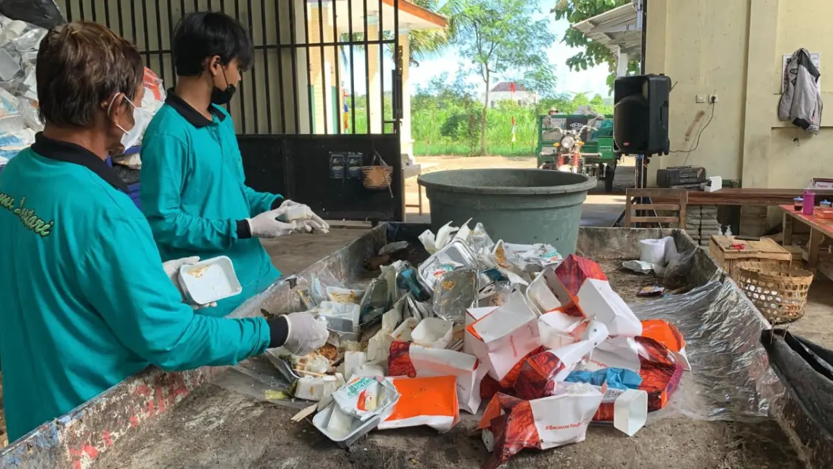 \PEMILAHAN: Personel Bank Sampah Kulwaru memilah sisa makanan dari kotak kertas - ANOM BAGASKORO/RADAR JOGJA