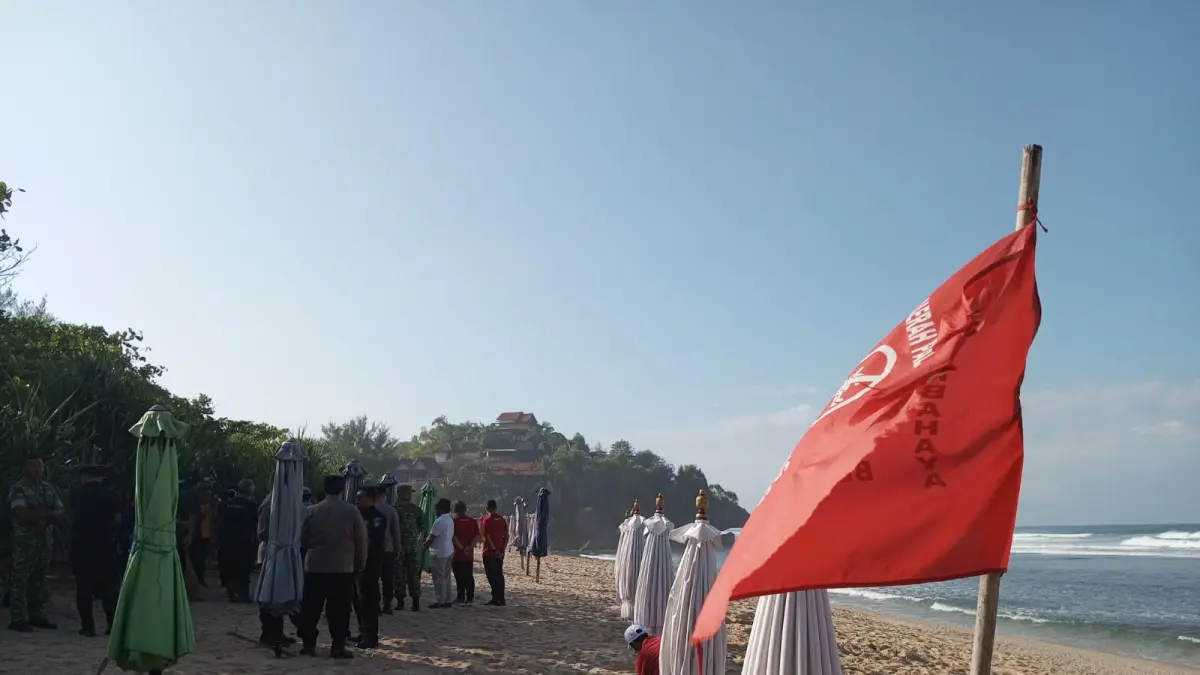 Satlinmas Rescue Istimewa Wilayah II Baron memasang bendera warna merah sebagai tanda area yang tidak boleh digunakan untuk bermain oleh wisatawan karena dinilai berbahaya dan berisiko tinggi - Yusuf Bastiar/Radar Jogja: