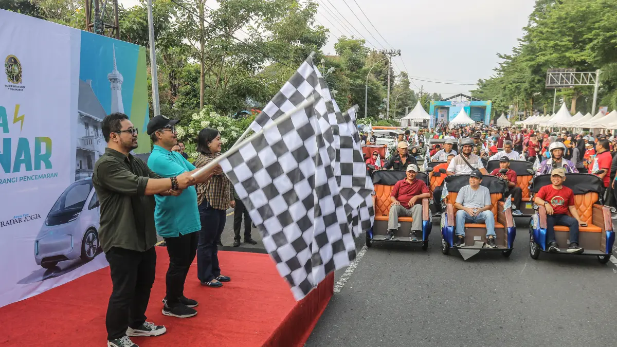 Wali Kota Jogja Hasto Wardoyo saat mengibarkan bendera tanda dimulainya parade kendaraan niremisi seperti becak listrik, motor listrik dan mobil listrik di Balai Kota Jogja, Sabtu (6/6).