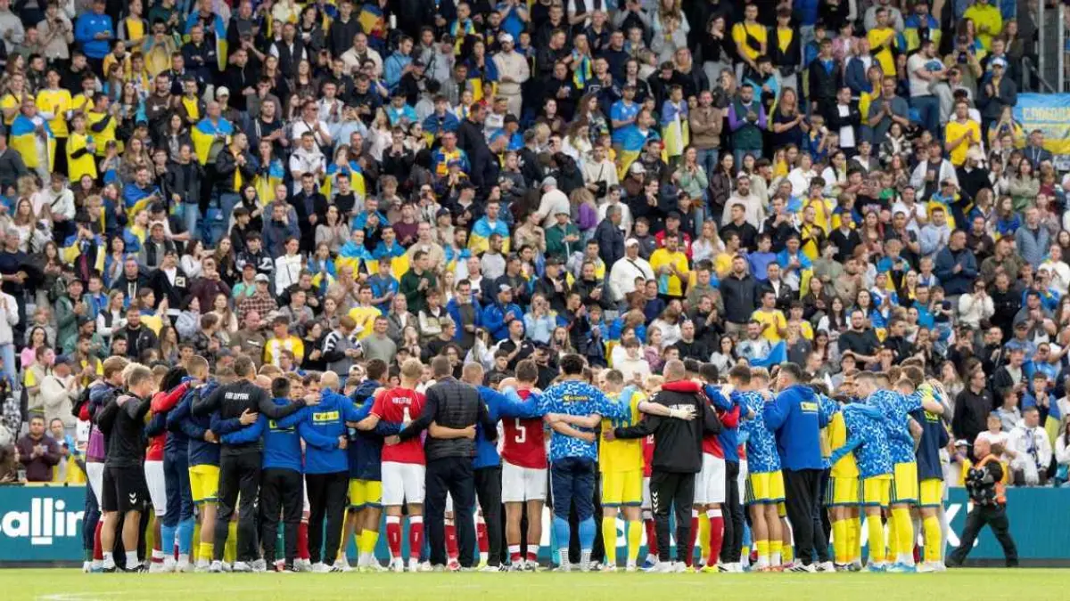 para pemain dan staff dari tim nasional Denmark dan Ukraina mengelilingi Cristian Eriksen yang kolaps di lapangan. (Bo Amstrup/Ritzau Scanpix via AP)