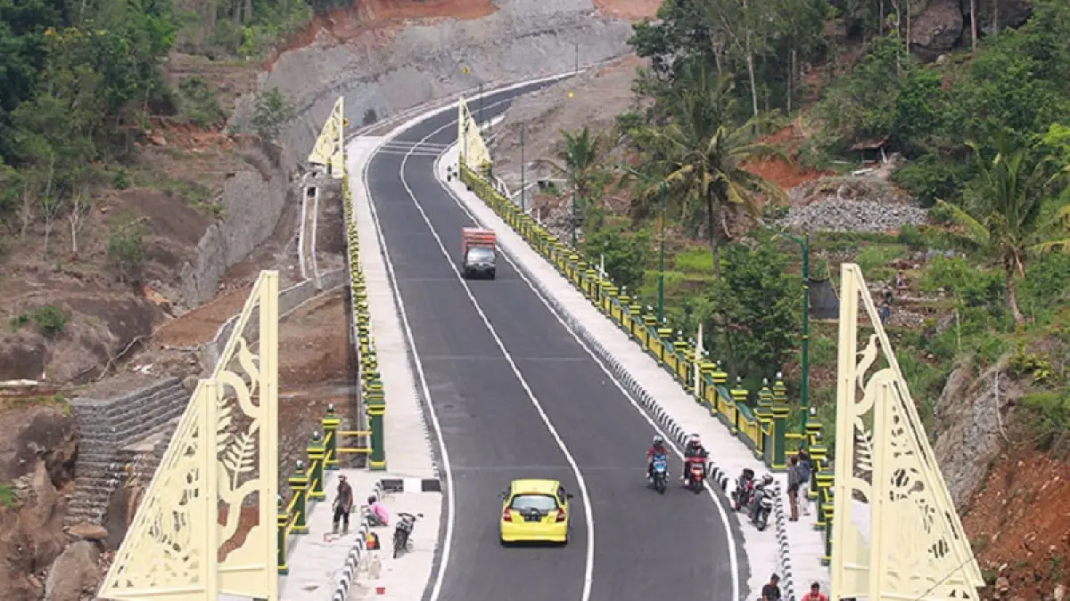 TERHUBUNG: Pengendara kendaraan bermotor melintas di jalan alternatif Sleman-Gunungkidul dan melewati jembatan Kedungkandang, di wilayah Kapanewon Patuk, Gunungkidul.
