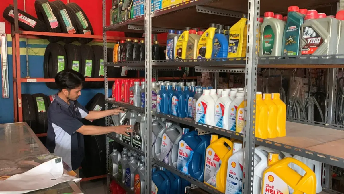 RAPI: Karyawan bengkel mobil menata produk oli yang kini merangkak naik. (ANOM BAGASKORO/RADAR JOGJA)