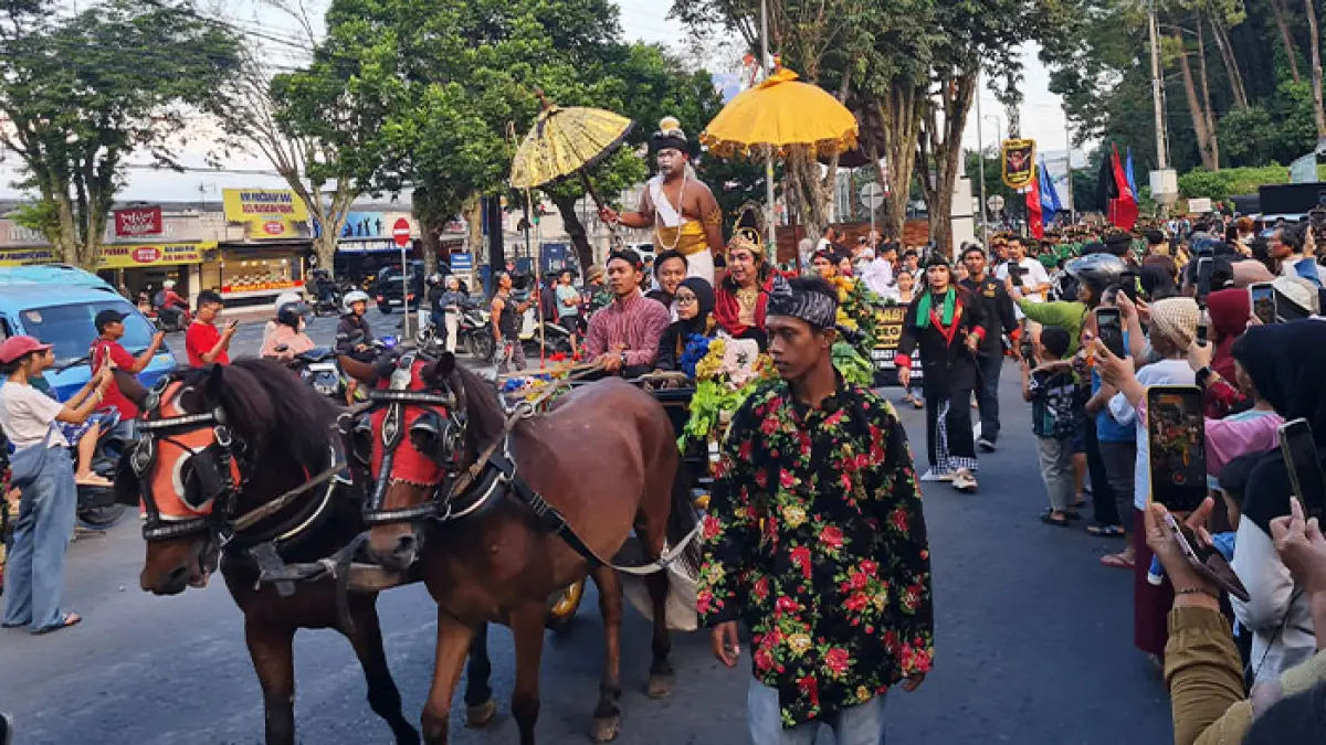 MERIAH: Kirab Gerebek Suro 2026 menyita perhatian warga di sepanjang ruas Jalan Ikhlas, Magelang, Senin (15/6) sore. (Naila Nihayah/Radar Jogja)