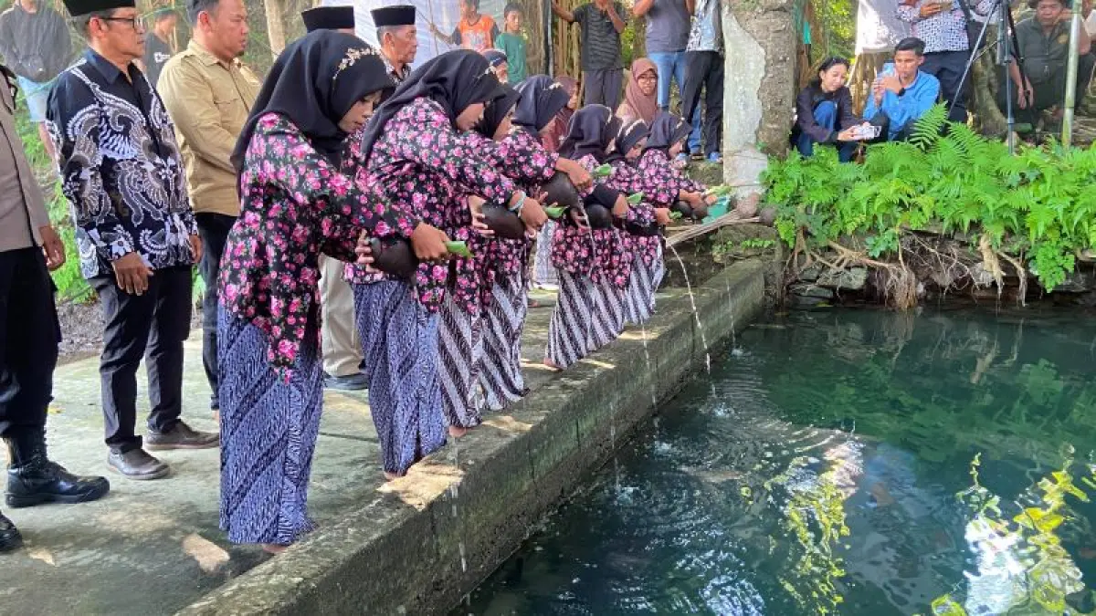 NGURI-URI BUDAYA: Warga Padukuhan Kaliberot, Argomuluo, Sedayu sedang menuangkan air saat pelaksanaan tradisi Nawu Sendang Sumur Gedhe Selasa (16/6).&nbsp;(Cintia&nbsp;Yuliani/Radar Jogja)