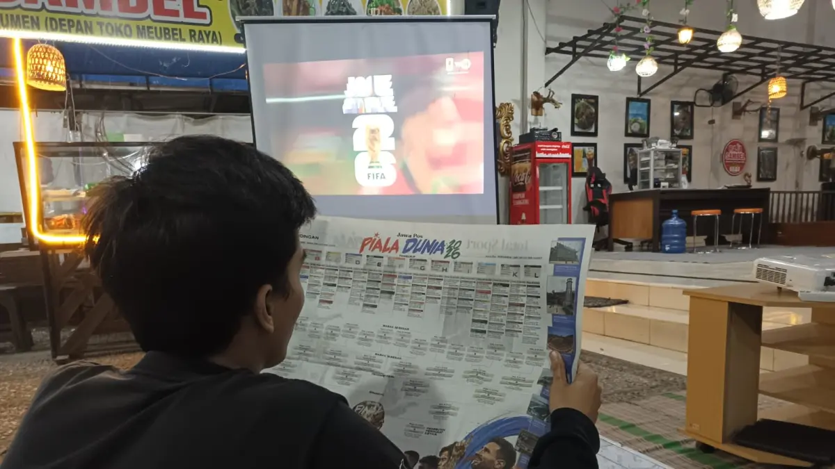 Seorang pecinta sepak bola di Kebumen sedang melihat jadwal Piala Dunia 2026 sembari menanti tim favoritnya bertanding. (M Hafied/Radar Jogja)

&nbsp;