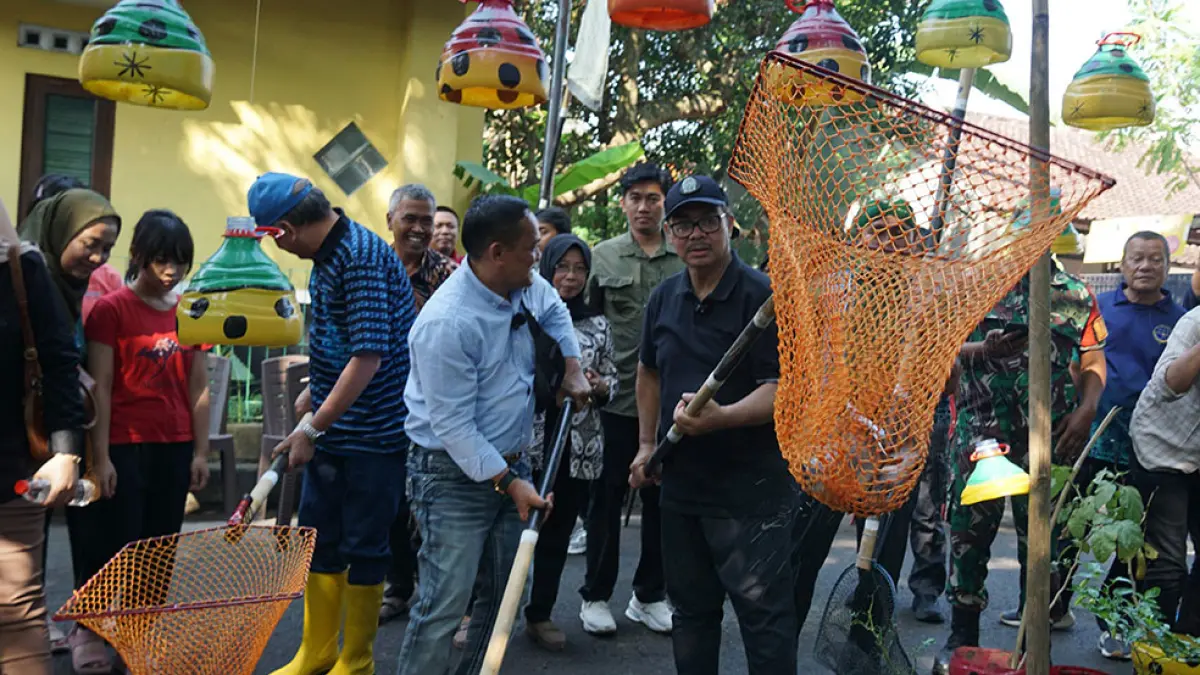 DULU PENUH SAMPAH: Wali Kota Jogja Hasto Wardoyo bersama masyarakat memanen ikan dengan jaring di saluran irigasi Karangmiri, Giwangan, Sabtu (20/6). 