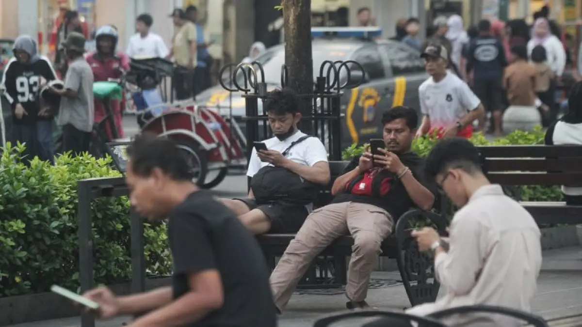 Warga mengakses layanan digital melalui telepon genggam di kawasan Malioboro, Kota Jogja Selasa (23/6). Maraknya ancaman siber dan kasus kebocoran data mendorong perlindungan data pribadi menjadi salah satu prioritas utama dalam menjaga keamanan ruang digital. (Guntur Aga Tirtana/Radar Jogja)