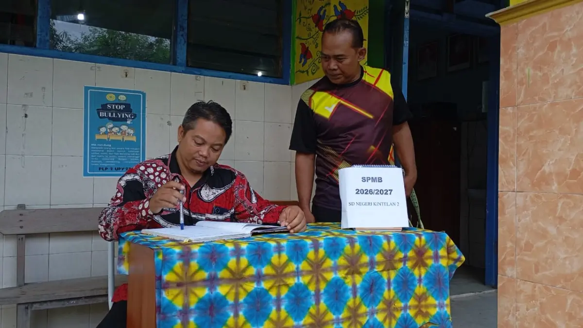 MENUNGGU: Kepala SD Negeri Kintelan 2 Jogja Kuswanto (batik) didampingi tenaga pengajar saat menunggu pendaftaran siswa baru, Jumat (26/6/2026). (FOTO: IWAN NURWANTO/Radar Jogja)