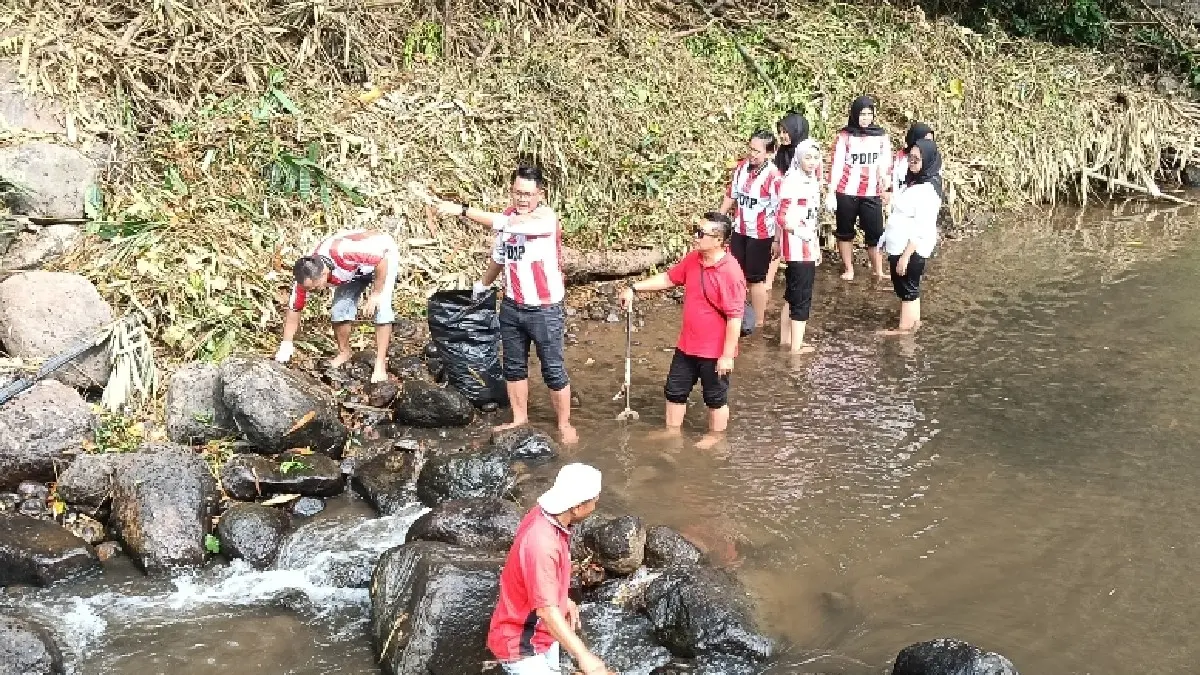 NYEMPLUNG KALI: Wakil Bupati Sleman yang juga Ketua DPC PDI Perjuangan Sleman Danang Maharsa bersama kader partai saat bersih-bersih sungai di Desa Wisata Lestari Kaliku Gabugan, Pandowoharjo, Sleman, Sabtu (27/6/2026). (YOGI IP/RADAR JOGJA)
