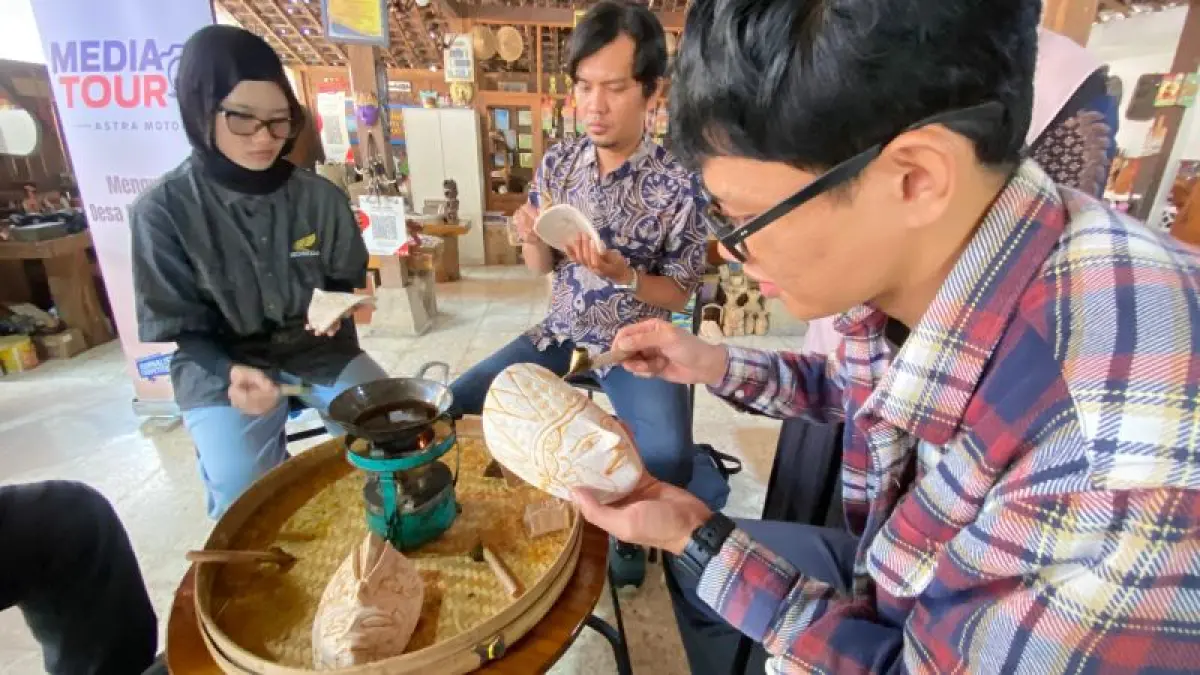MANUAL: Pengunjung Desa Wisata Krebet saat belajar membatik di atas kayu yang sudah diukir. (Cintia&nbsp;Yuliani/Radar Jogja)