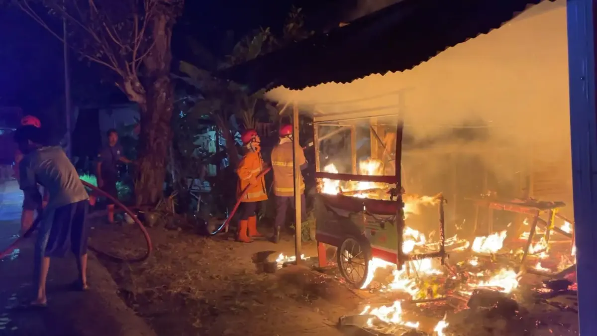 USAHA: Petugas Damkarmat Kulon Progo berusaha memadamkan api yang telah membakar kios. (Foto: ANOM BAGASKORO/RADAR JOGJA)&nbsp;