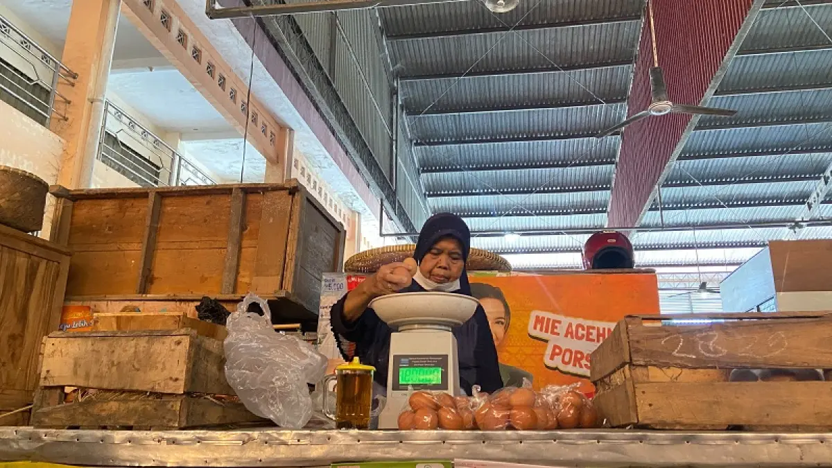 JUAL BELI: Pedagang telur ayam sedang melayani pembeli di lapaknya, Jumat (3/7/2026). Cintia Yuliani/Radar Jogja
