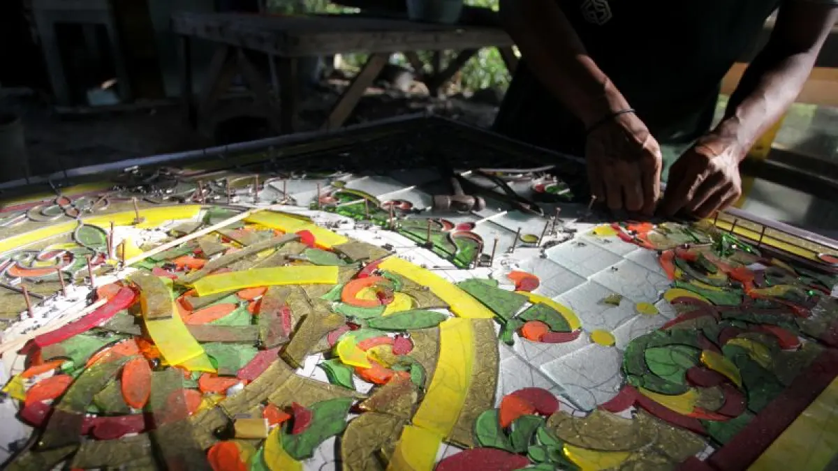 ARTISTIK: Perajin menyelesaikan proses pembuatan kaca patri di Fortuna Art Glass, Krandon, Pandowoharjo, Sleman Kamis (3/7). (GUNTUR AGA TIRTANA/RADAR JOGJA)
