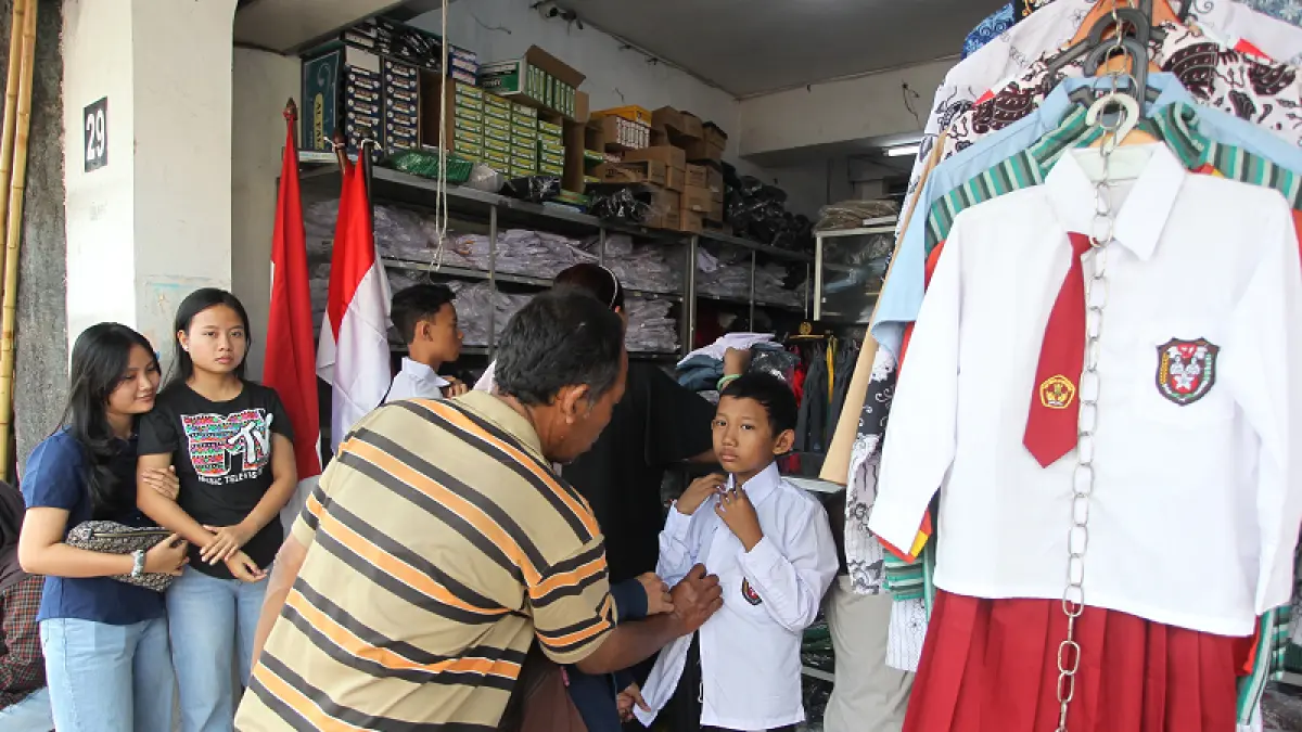 Orang tua mendampingi anaknya membeli seragam sekolah di Jalan Ibu Ruswo, Kota Jogja, Senin (6/7/2026). Foto : Guntur Aga Tirtana/Radar Jogja