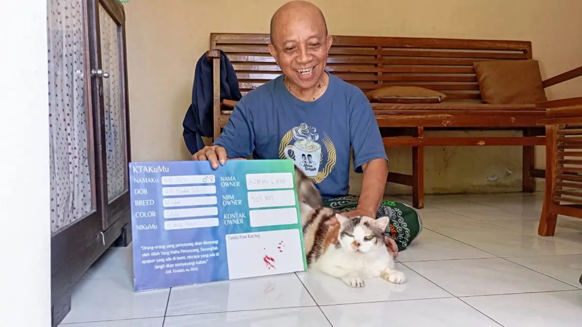 Wakil Ketua Pimpinan Wilayah Muhammadiyah DIY Azman bersama dengan Messi kucing pertama pemilik Kartu Tanda Anggota Muhammadiyah saat ditemui di kediamannya, Rabu (8/7/2026). (Foto: Iwan Nurwanto/Radar Jogja)