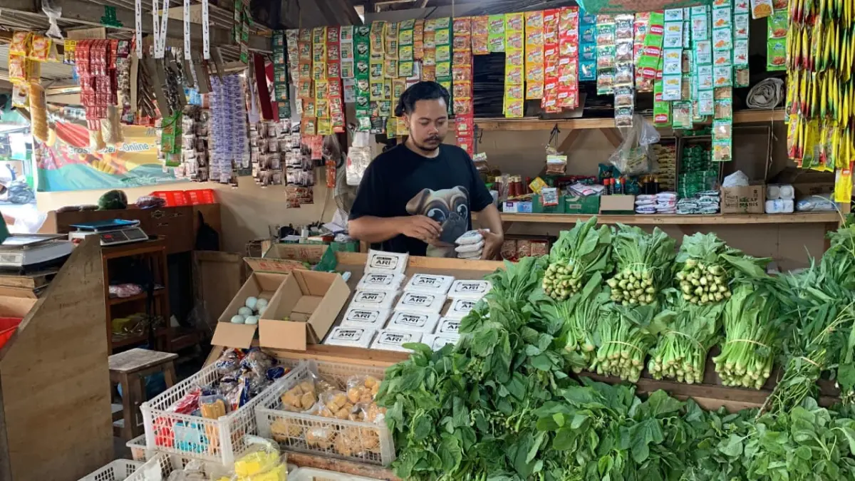DAGANG: Jalu menata sayuran agar terlihat rapi untuk menarik calon pembeli. (ANOM BAGASKORO/RADAR JOGJA)