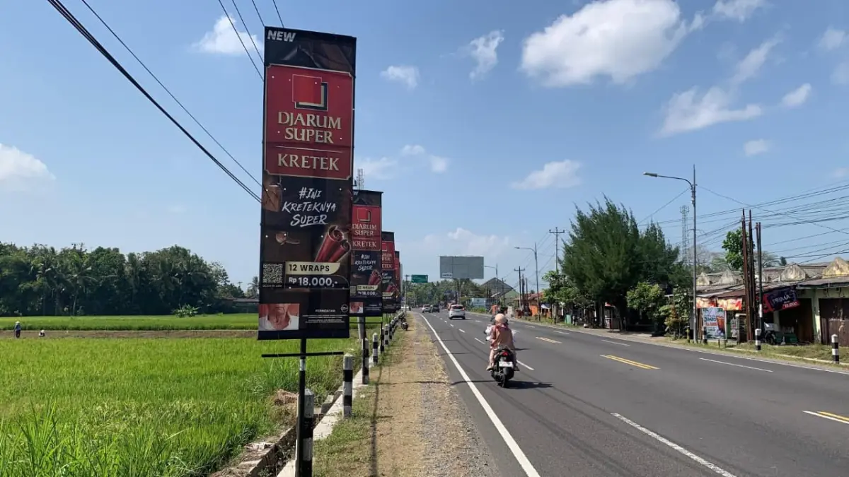 PELANGGARAN: Reklame rokok terpasang di Simpang Tiga Tugu Pensil, peletakan reklame diduga tak berijin tapi telah membayar pajak. (ANOM BAGASKORO/RADAR JOGJA)