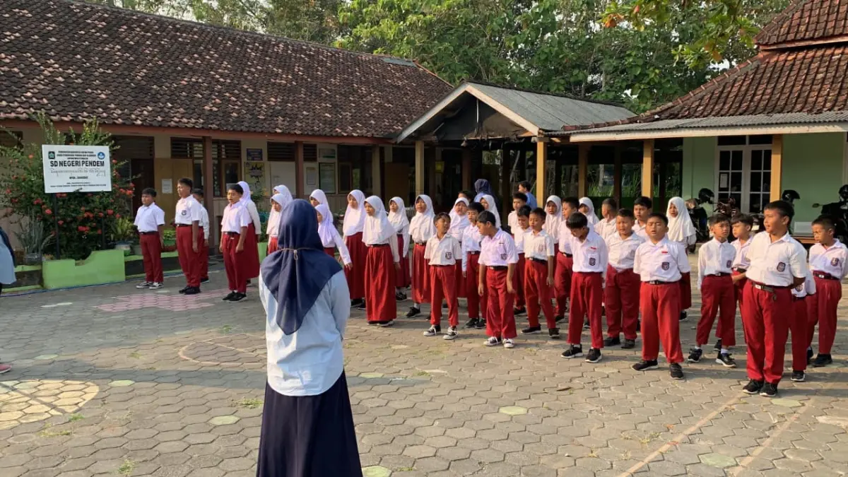 RAPI: Guru SDN Pendem mengatur barisan siswa didiknya sebelum menikuti pembelajaran. (ANOM BAGASKORO/RADAR JOGJA)