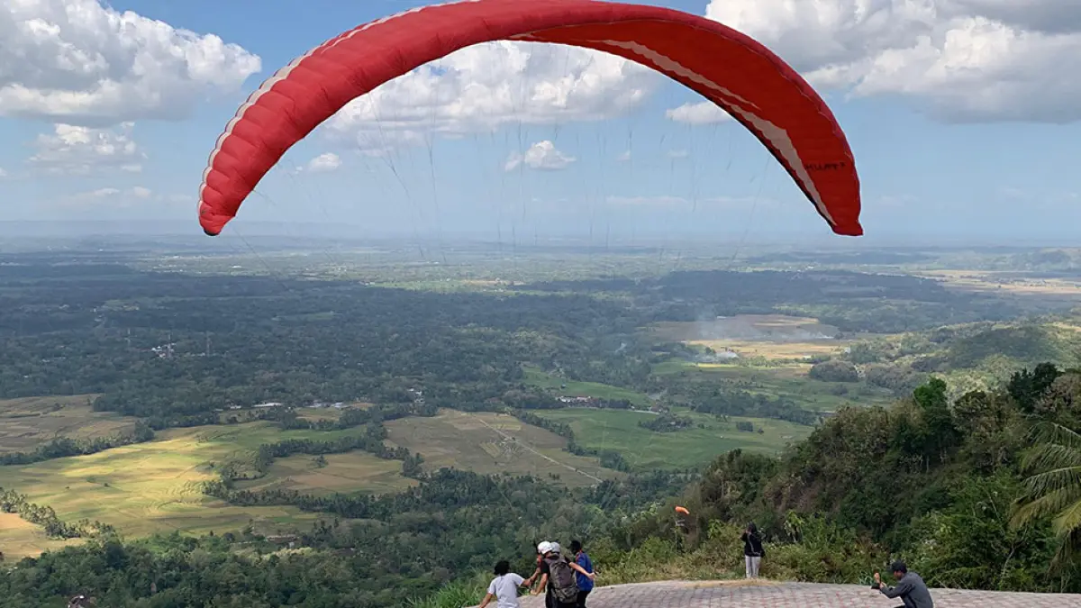 TERBANG: Pilot paralayang berhasil lepas landas dari Giri Sembung, Banjarasri, Kalibawang, Kulon Progo. Anom Bagaskoro/Radar Jogja