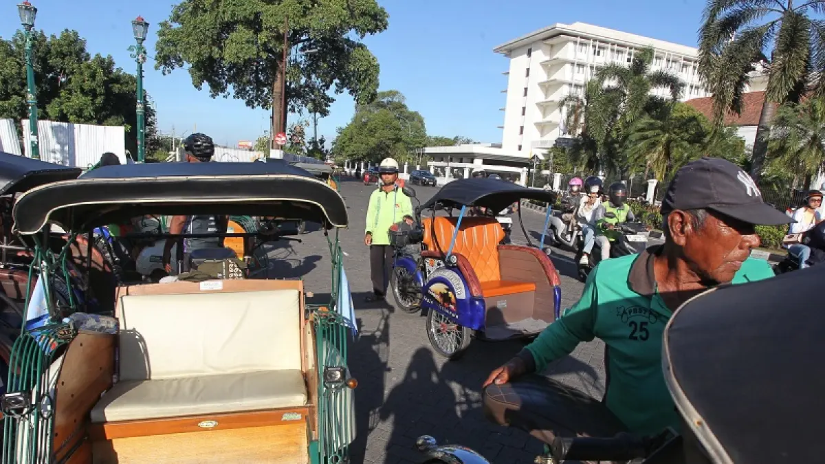Pengemudi becak listrik mengantar wisatawan berkeliling kawasan Malioboro, Kota Jogja, Minggu (26/7/2026). Sejumlah pengemudi becak listrik mengeluhkan daya tahan baterai yang dinilai belum sesuai harapan karena lebih cepat habis dibandingkan jarak tempuh yang dijanjikan. Foto : Guntur Aga Tirtana/Radar Jogja 