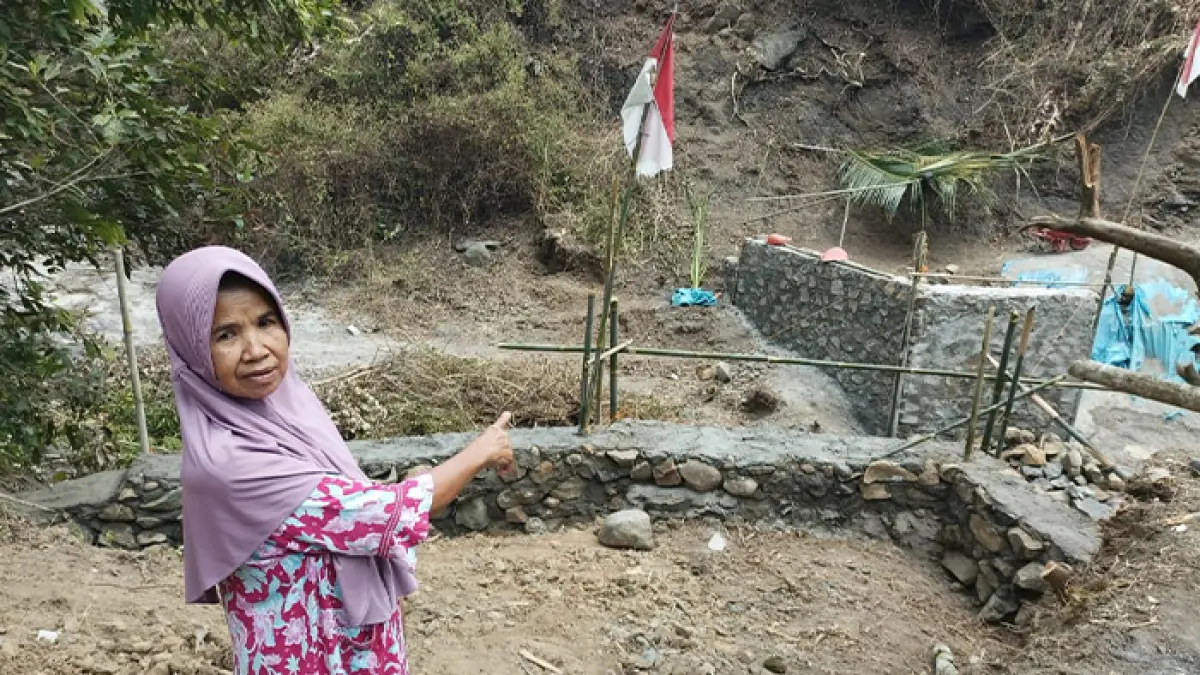 Surtini, 62, menunjukkan pembangunan jembatan umum yang ia sumbangkan dari hasil menjual sawah miliknya. (M. Hafied/Radar Jogja)