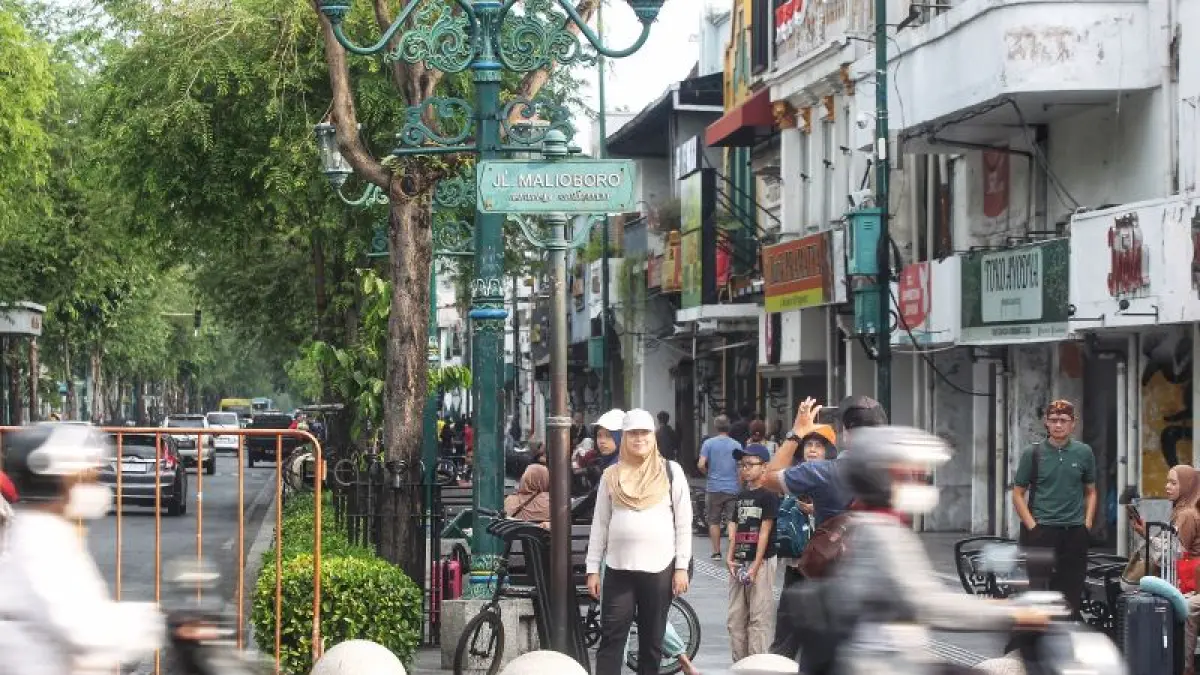 Wisatawan berfoto di depan plang Jalan Malioboro, Kota Jogja Selasa (28/7). (Guntur Aga Tirtana/Radar Jogja)